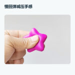 Hand squeezing a pink star-shaped PU foam stress ball to show slow-rising compression