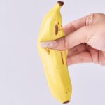 Hand squeezing a yellow banana squishy toy