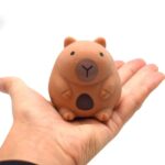 Capybara squishy toy resting in a hand for size reference