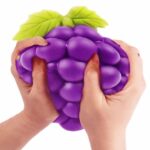 Hands squeezing jumbo purple grape cluster squishy toy