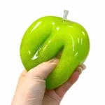 Hand squeezing glossy green apple squishy toy