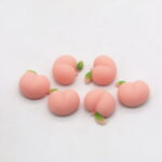 Multiple peach-shaped squishy toys on white background