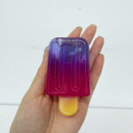 Gradient popsicle squishy toy shown in hand for wholesale size reference